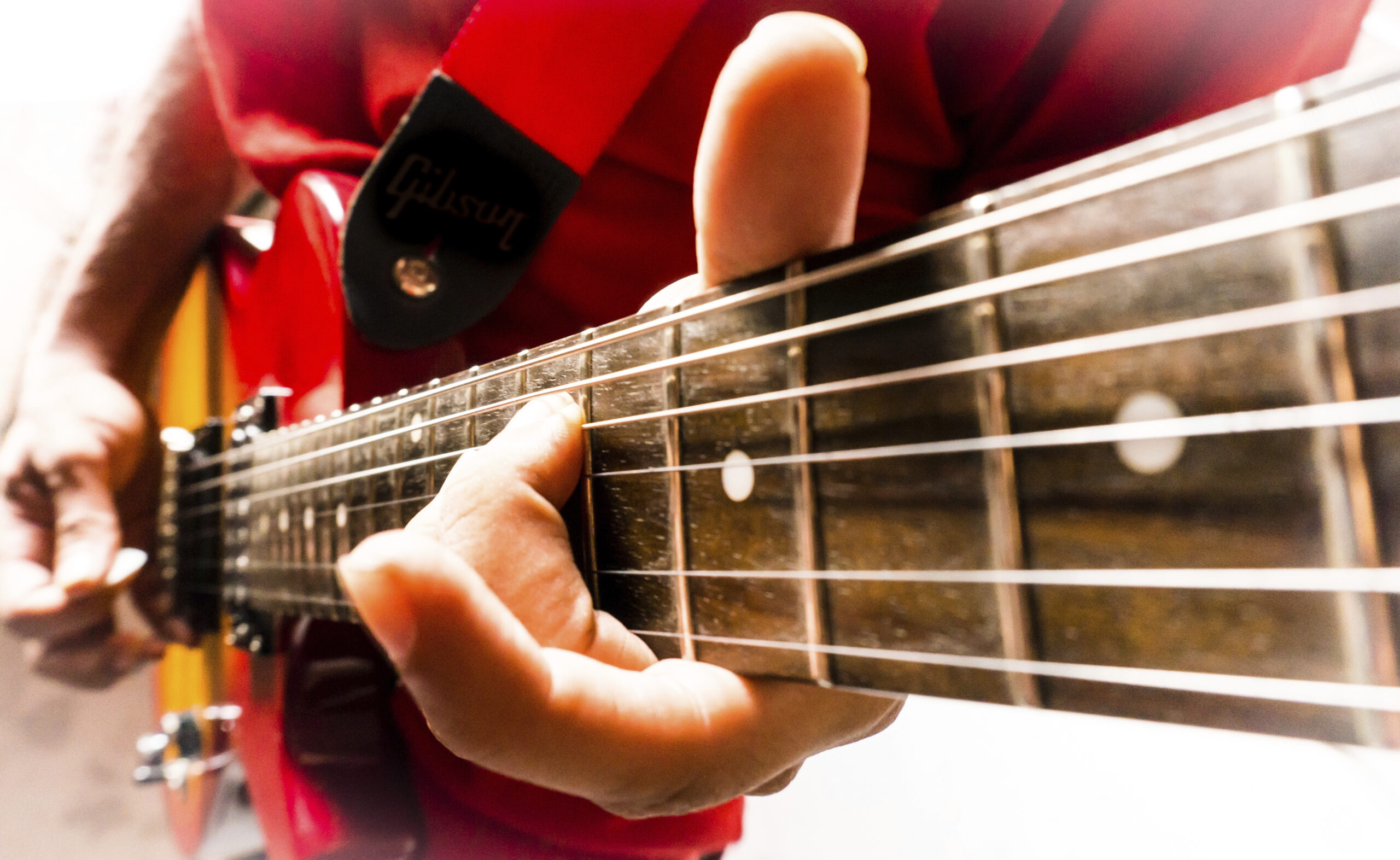 Musician playing a chord on an electric les paul guitar.